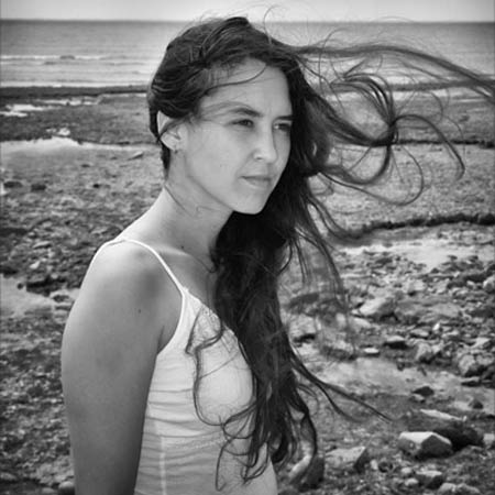 photographie en noir et blanc de Julie, Guerrière Pacifique, les cheveux au vent, au bord de la mer