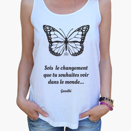 photographie d'une femme qui porte un débardeur blanc avec un papillon noir, au message inspirant Sois le Changement que tu souhaites voir dans le monde...